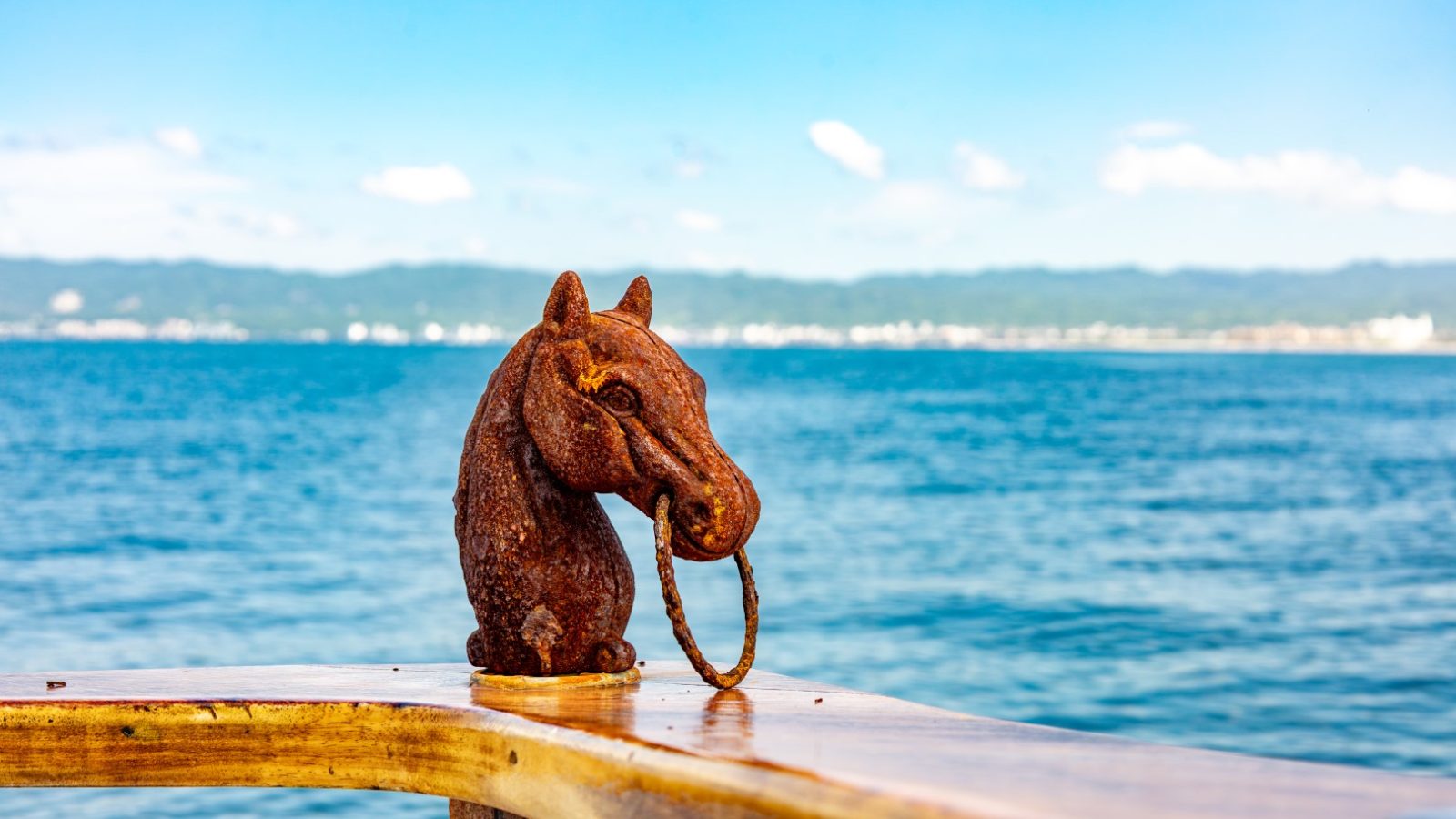 Cabeza de caballo de bronce en la borda del yate Steel n Time, con la costa de Nuevo Vallarta al fondo